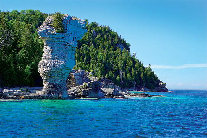Flowerpot Island during a sunny day showcasing the steep limestone cliffs and lush forest of Bruce Peninsula National Park