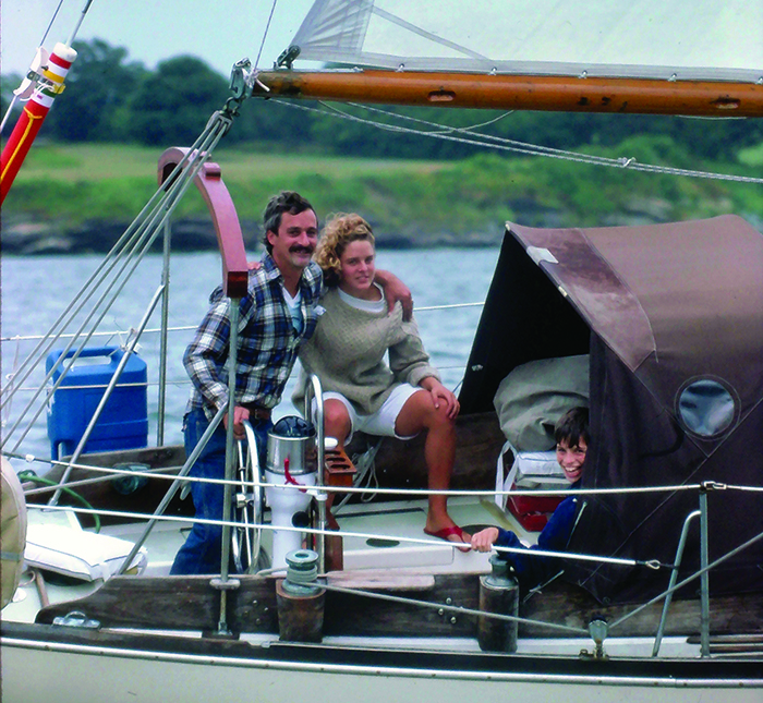 Middle-aged Caucasian male, teenage blonde female and young male aboard a white sailboat.