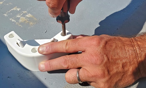 Screws being driven into a white chock.