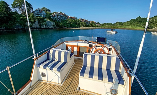 White and blue seat cushions on a flybridge of a vessel on open waters.