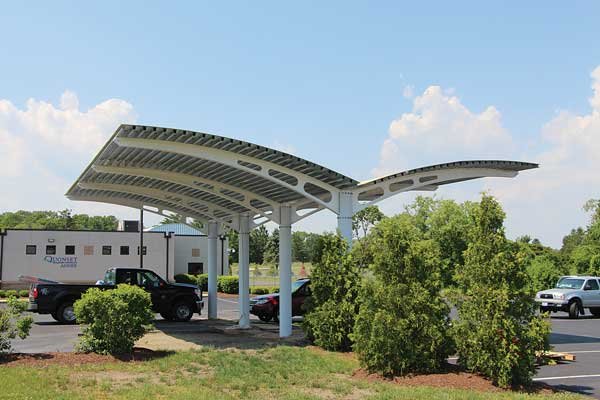 wide shot of a composite solar arch with cars parking underneath