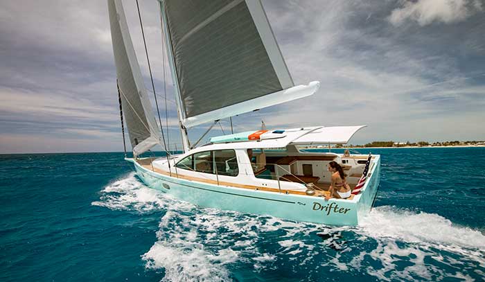 A seafoam-colored sailboat underway with the word Drifter on the side 