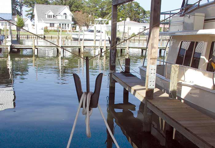 A bracket hanging from the roof of a boathouse makes it easy to drop or pick up bow lines