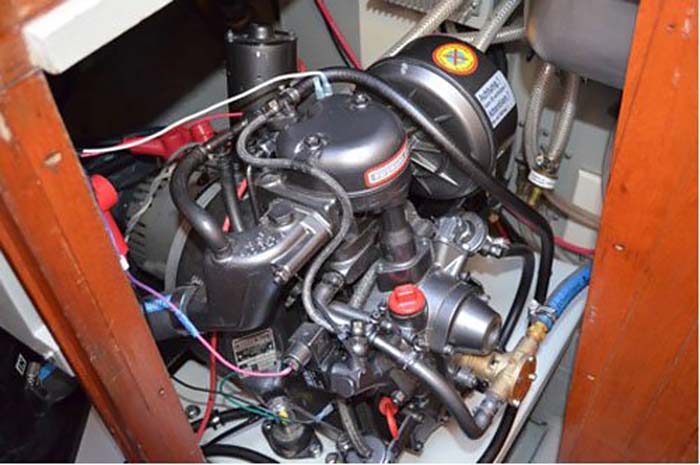 Close-up of a single-cylinder diesel boat engine with various wires and hoses
