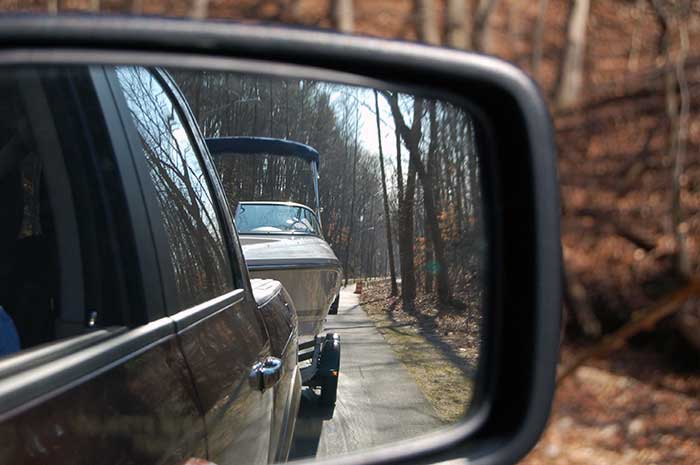 Rear view mirror view of towing a boat