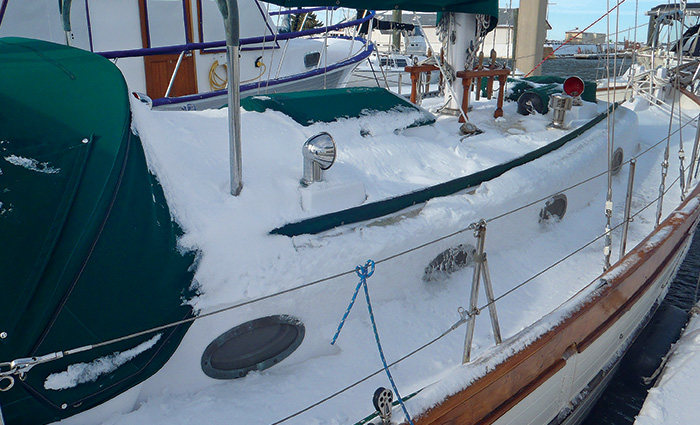 A snow covered white vessel docked
