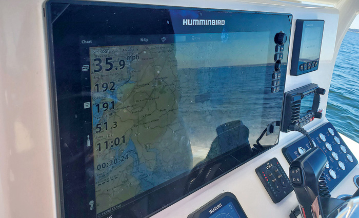 Up close photo of a  GPS navigation screen on a white boat at sea.
