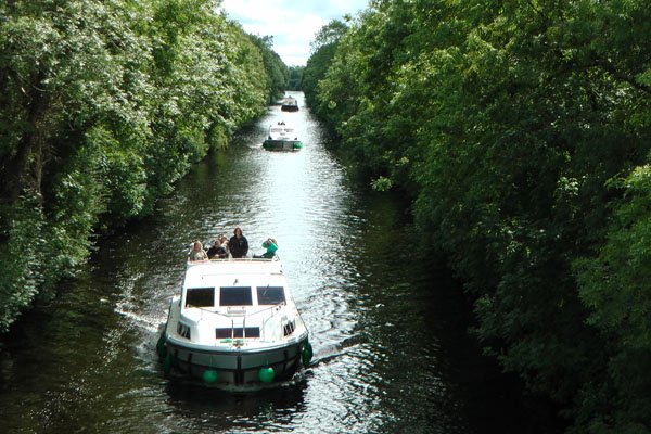 Full view of three boats boating through an Ireland Canal