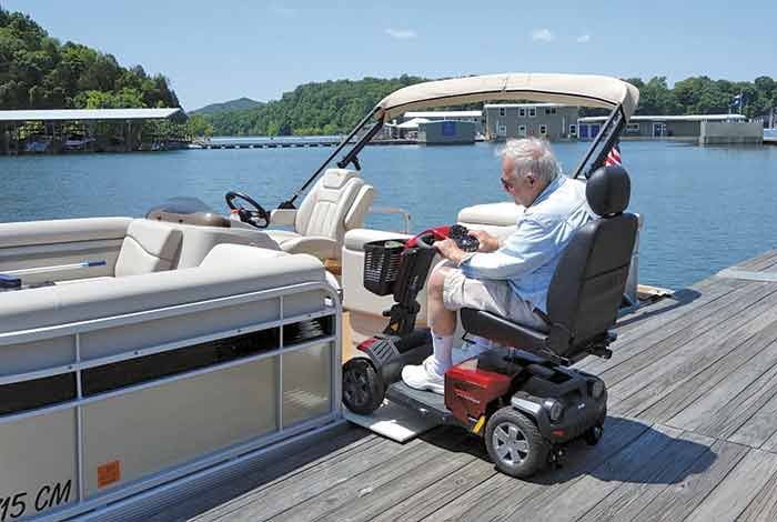 A man drives his scooter onto a pontoon boat