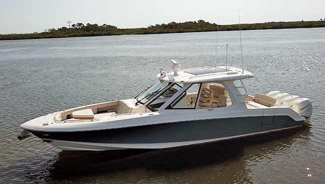 A white and blue Boston Whaler 380 Realm powerboat in the water