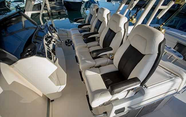 Four white and black chairs in a row at the helm of a powerboat