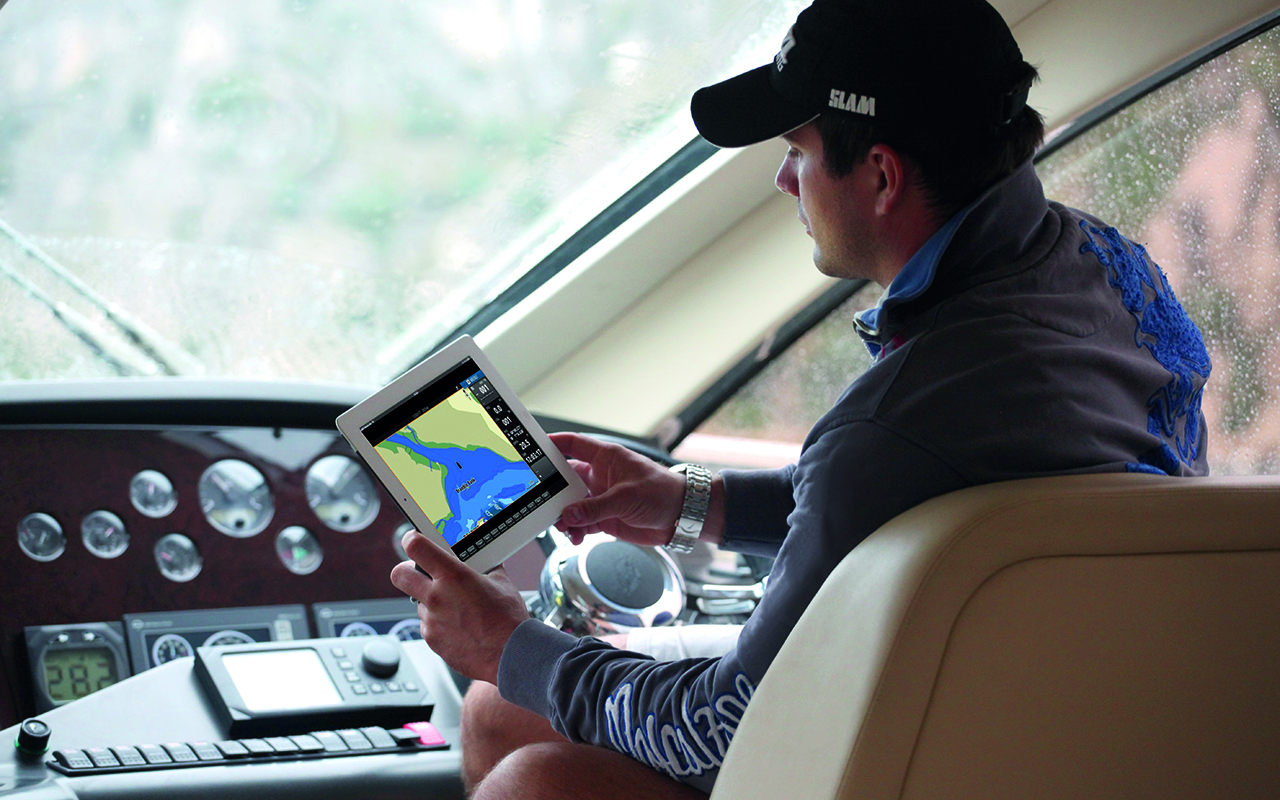 Man at Helm Using Tablet