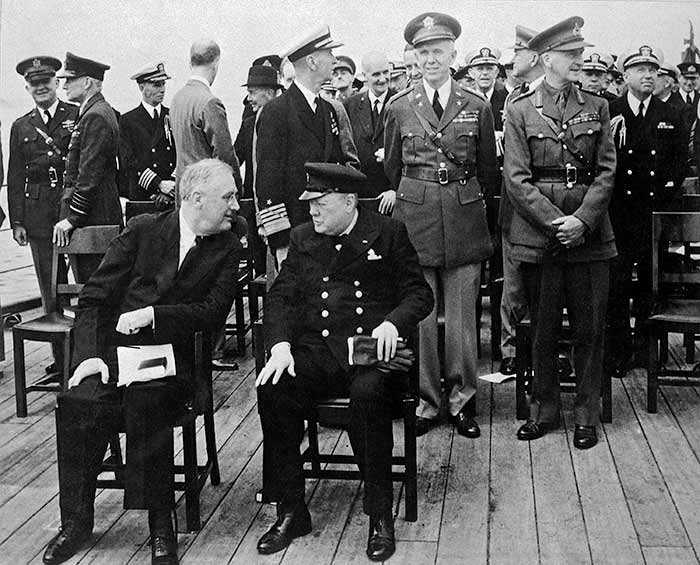 President Roosevelt and Prime Minister Churchill chat seated on the deck of HMS Prince