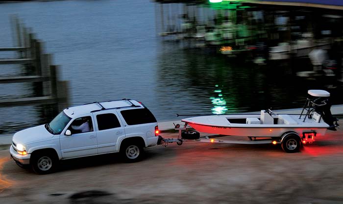 Towing boat on trailer with lights on