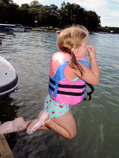 Young girl jumping off of boat