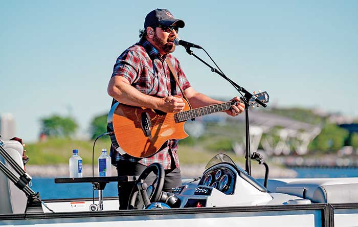 Country music star Rodney Atkins plays guitar in concert aboard his Lowe pontoon boat