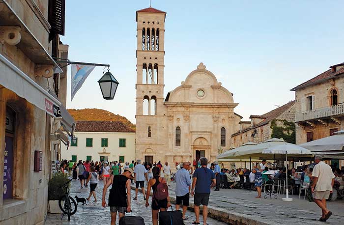 People walking along a street in front of St. ­Stephen’s Cathedral in Hvar Croatia