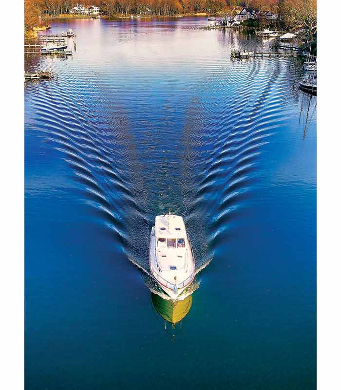 Photo Contest Cover Winner: A drone shot of the a boat as it was coming up Ridout Creek near Annapolis, with the confluence of Whitehall Creek in the background