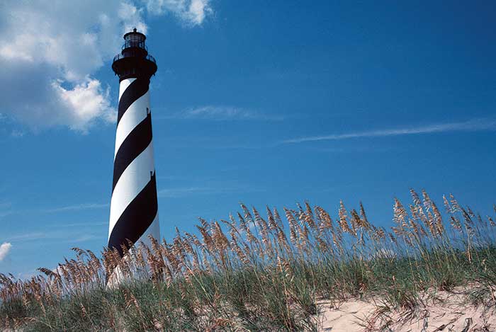 Hatteras Lighthouse behind dune wall and sea grass
