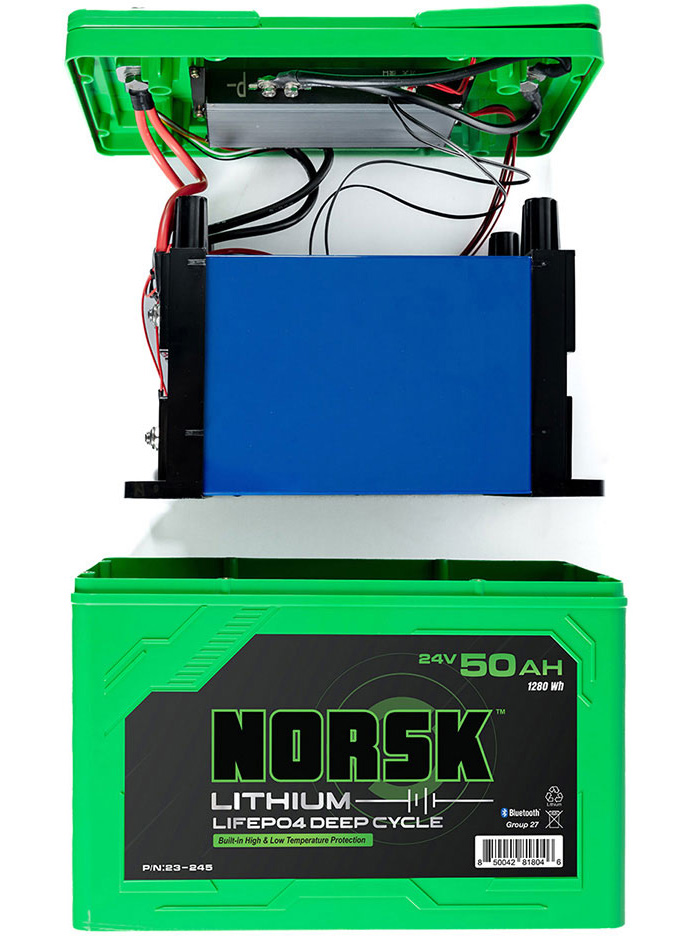 Green Norsk Lithium battery being installed on a boat by an adult male.