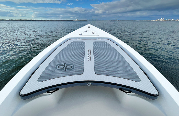 White and gray DeckPad providing cushion on the front of a boat in the open waters