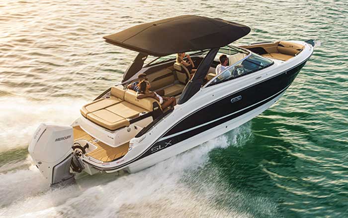 Three people in a Sea Ray SLX 260 Outboard cruising along the water