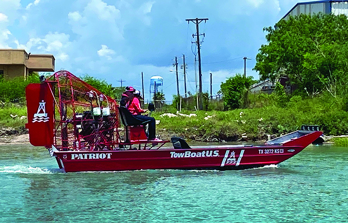 Red TowBoatU.S. airboat in action in shallow waters.