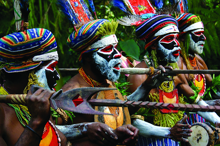 Four African males wearing colorful face paint 