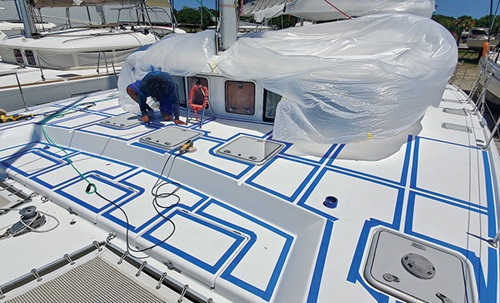Boat owner doing prep work to boat prior to painting.