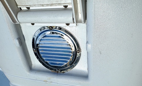 Vent on the side of a white cooler providing airflow.