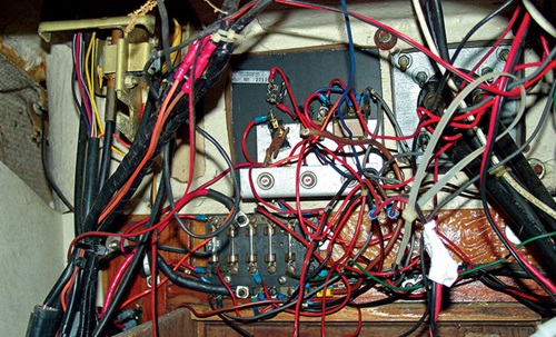 Numerous tangled red, blue and yellow wires of a digital switching module.