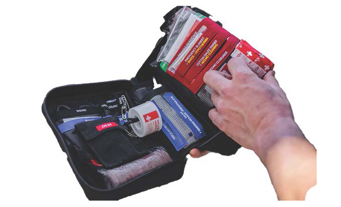 Black first aid kit opened stocked with water-proof medical items.